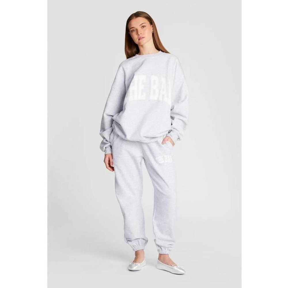 This is a pre-owned women's "THE BAR" sweatshirt in light heather grey, size L